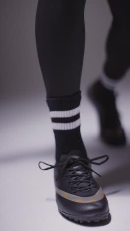 Vertical-Video-Close-Up-Studio-Shot-Of-Female-Footballer-Tying-Training-Shoes-Or-Football-Boots-2